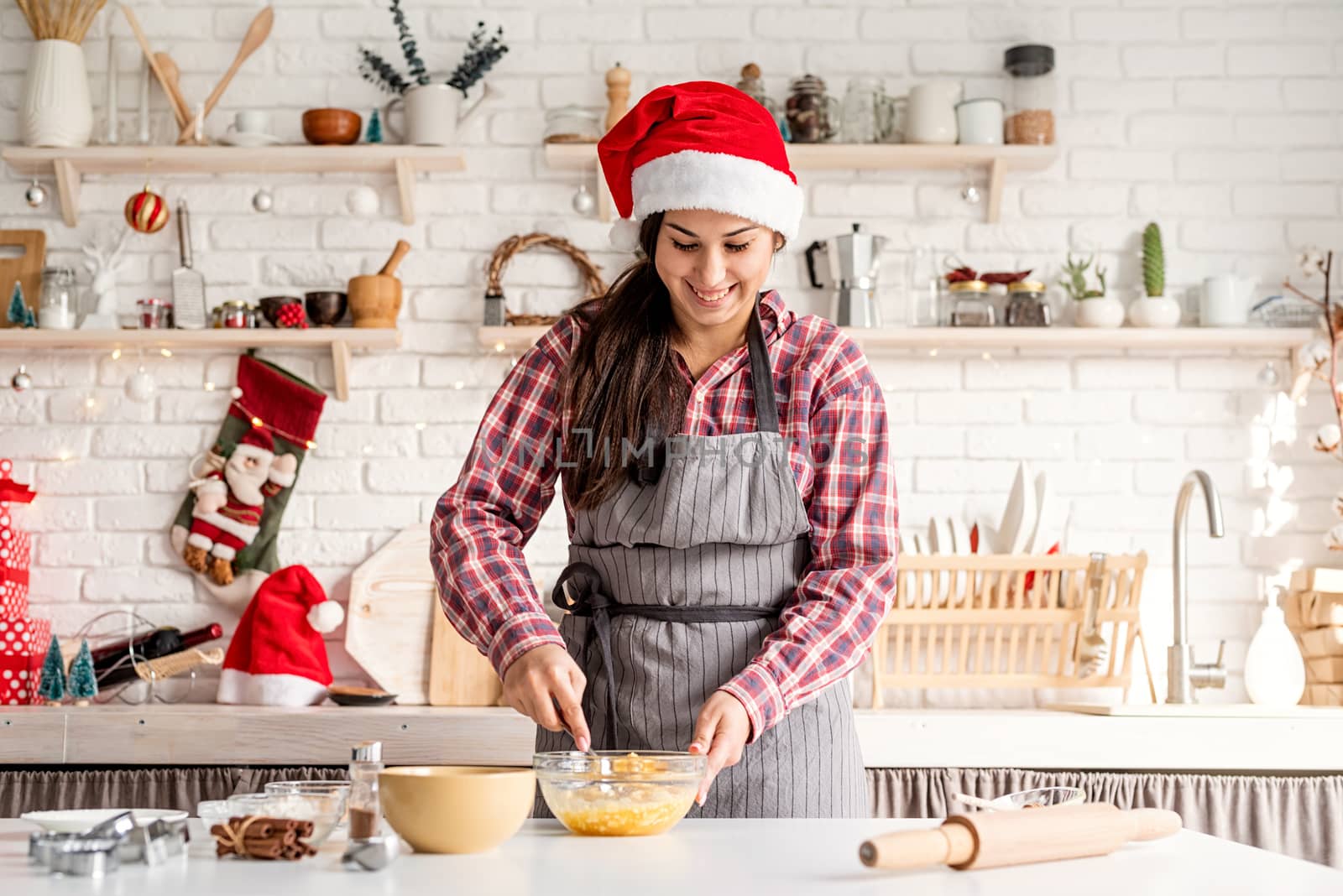 Young latin woman whisking eggs cooking at the kitchen by Desperada