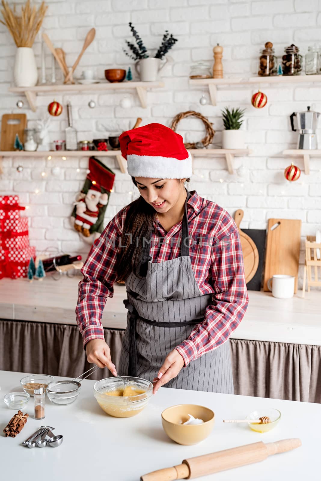 Young latin woman mixing dough cooking at the kitchen by Desperada