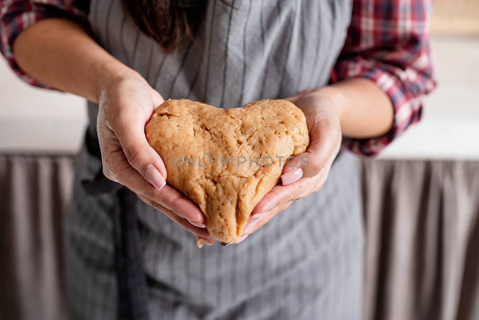 Cooking and baking. Woman hands holding heart shaped dough