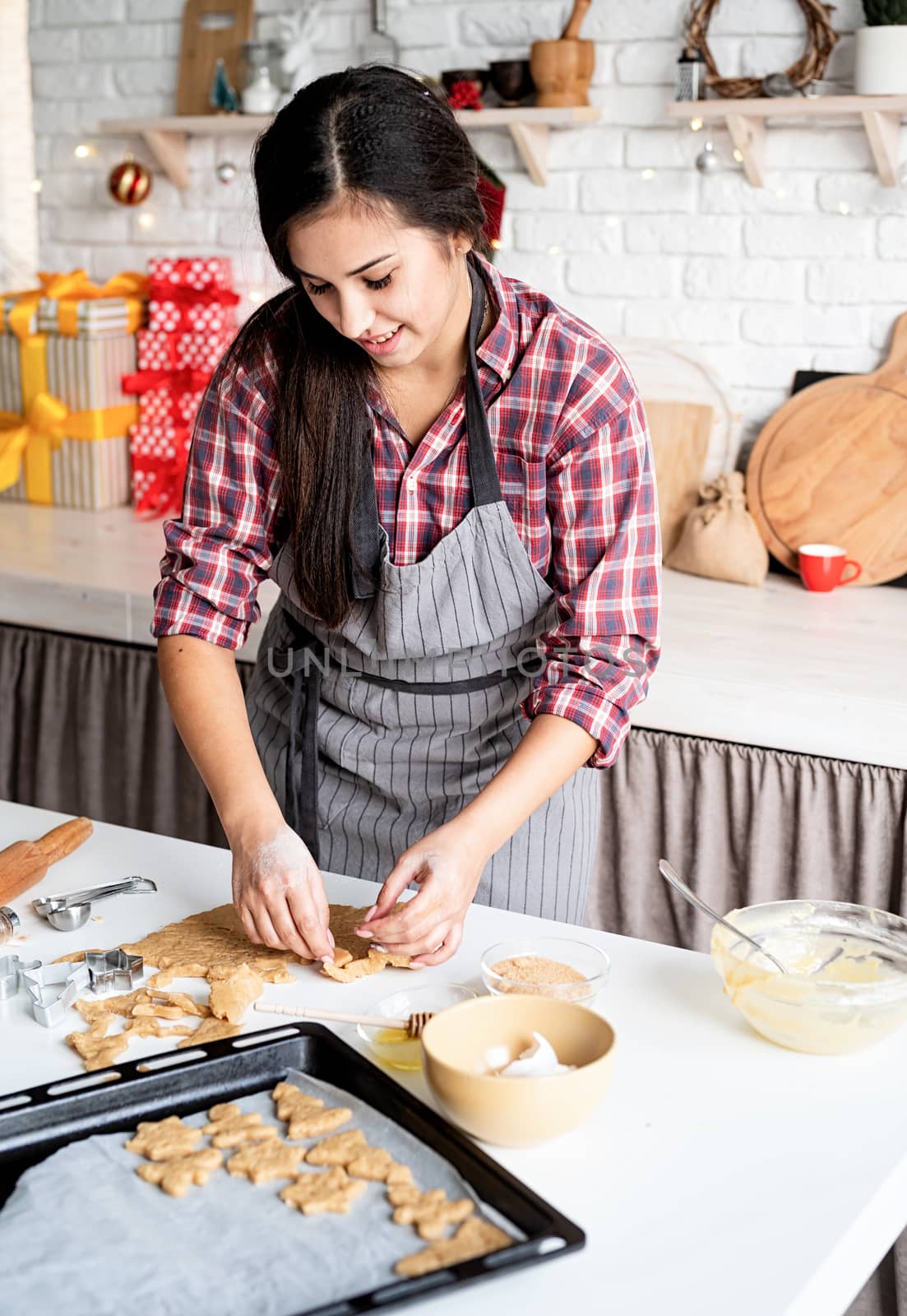 Young brunette woman baking cookies at the kitchen by Desperada