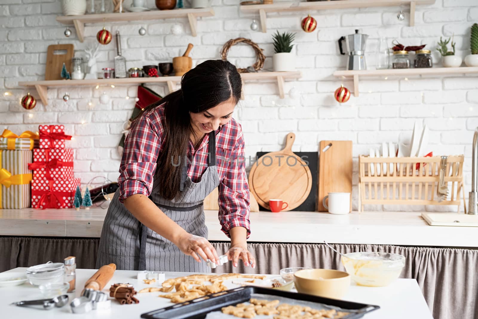 Cooking and baking. Young brunette woman baking cookies at the kitchen