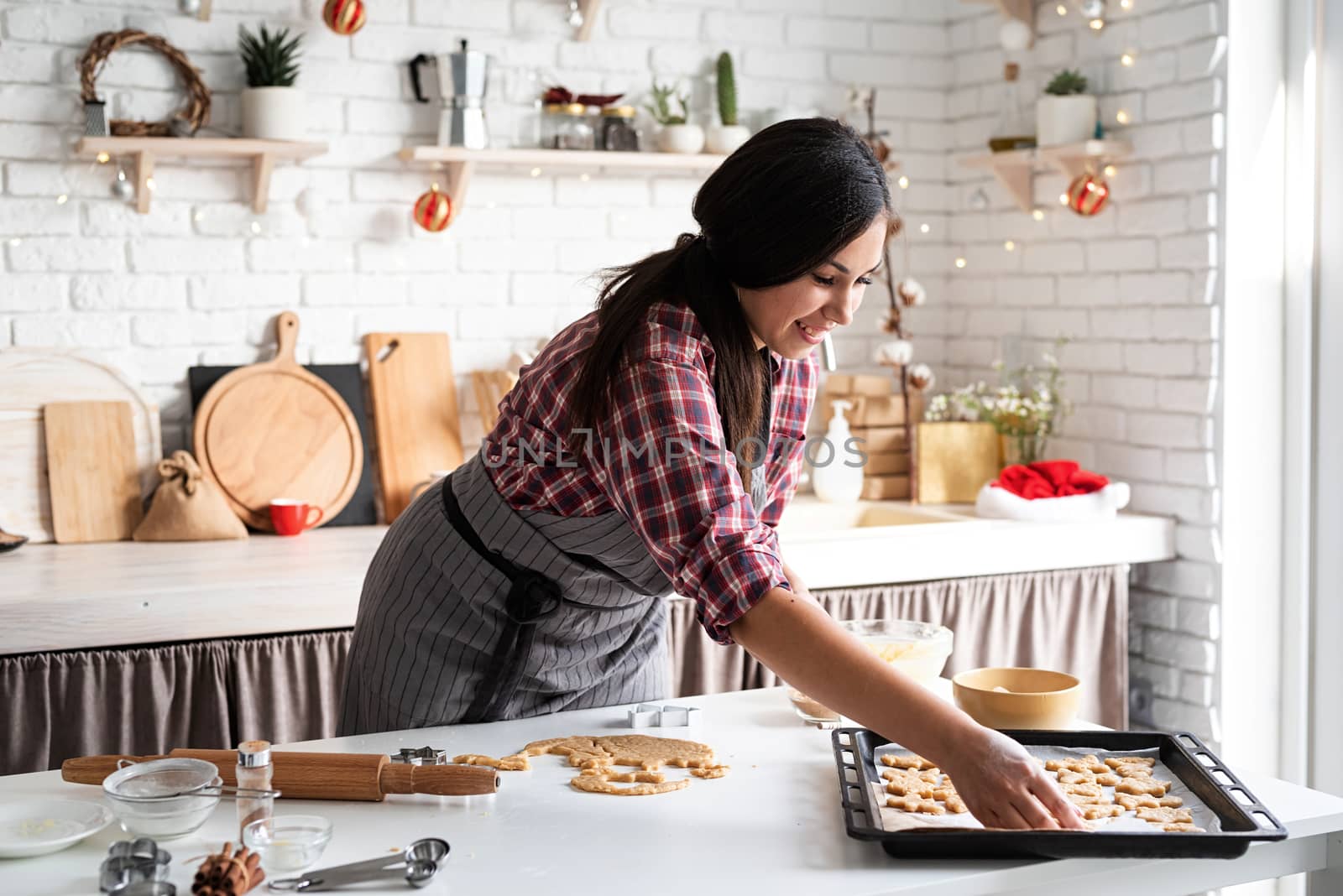 Cooking and baking. Young brunette woman baking cookies at the kitchen