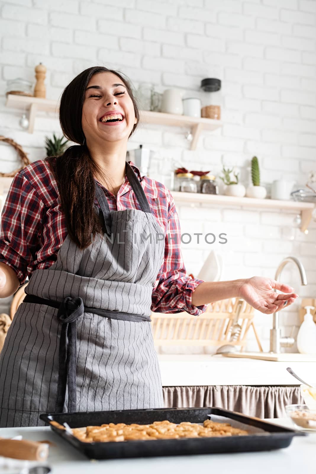 Cooking and baking. Young brunette woman baking cookies at the kitchen