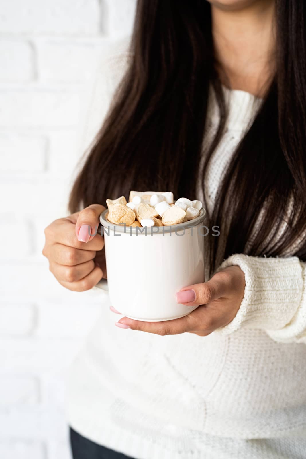 brunette woman holding a cup of marshmallow cocoa by Desperada