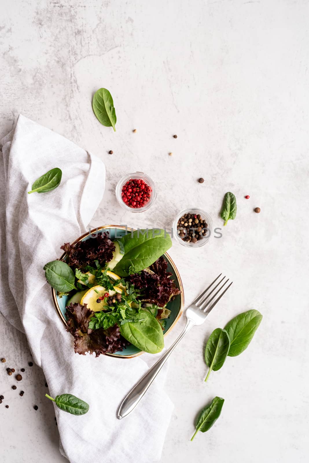 Healthy veggie salad with spinach, red lettuce, cucumbers and greenery top view flat lay