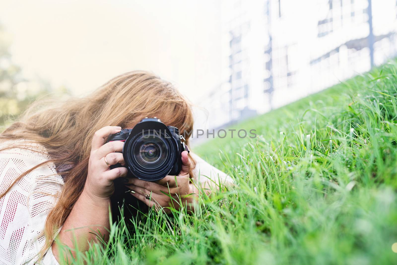 Body positive. Portrait of overweight woman taking pictures with a camera in the park