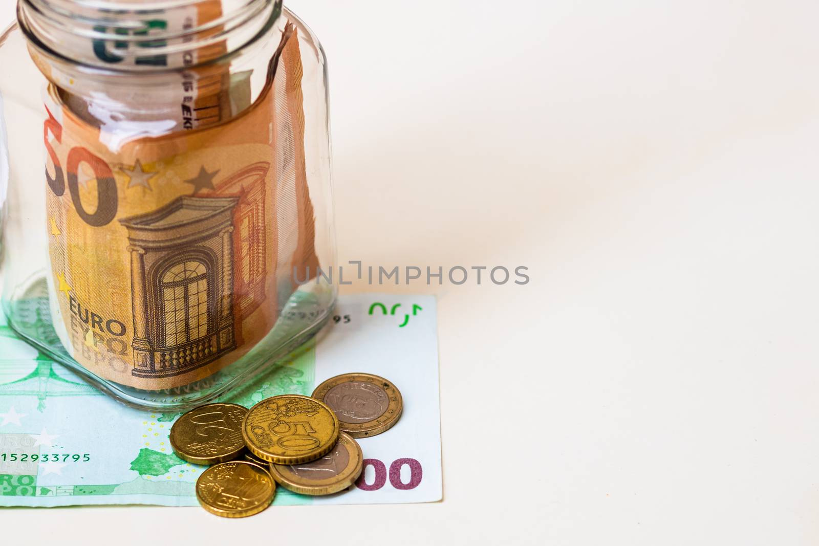 Composition with saving money banknotes in a glass jar. Concept of investing and keeping money, close up isolated.