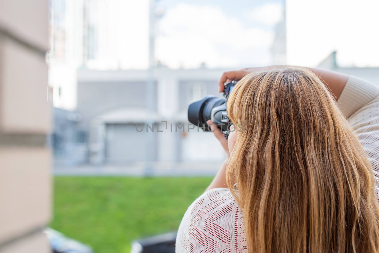 Portrait of overweight woman taking pictures with a camera outdoors by Desperada