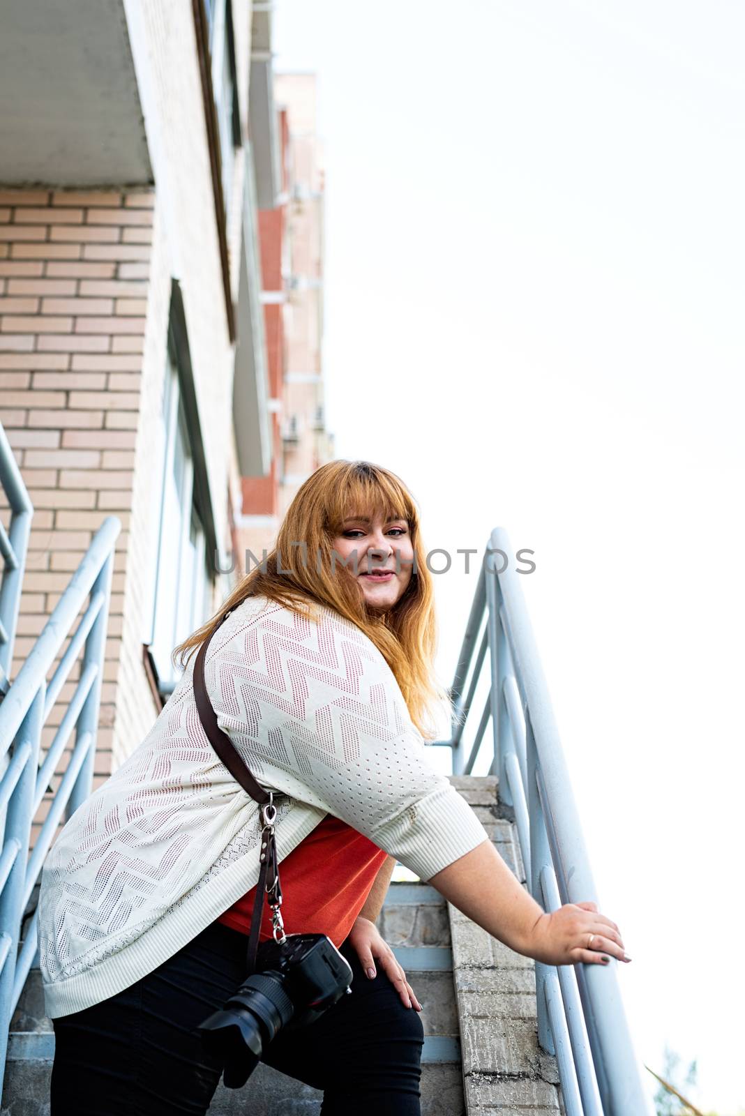 Travel, tourism and entertainment. Plus size woman photographer working at the street