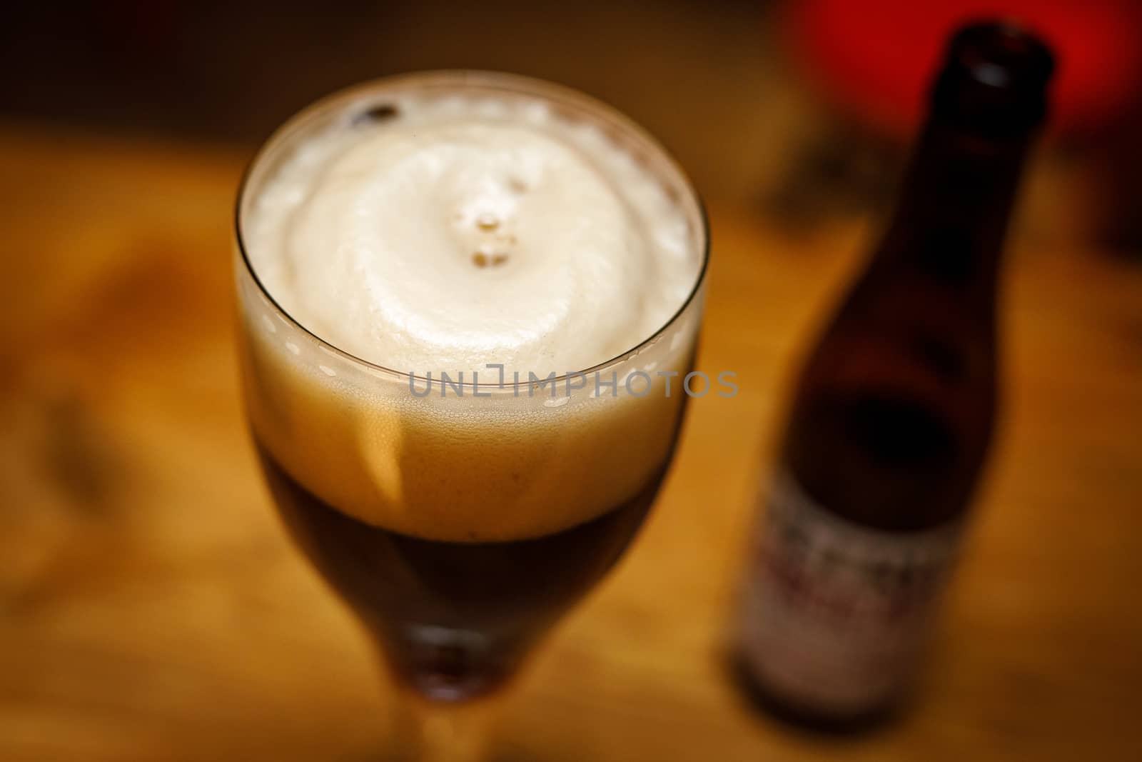 A glass of beer with foam. Top view in a pub