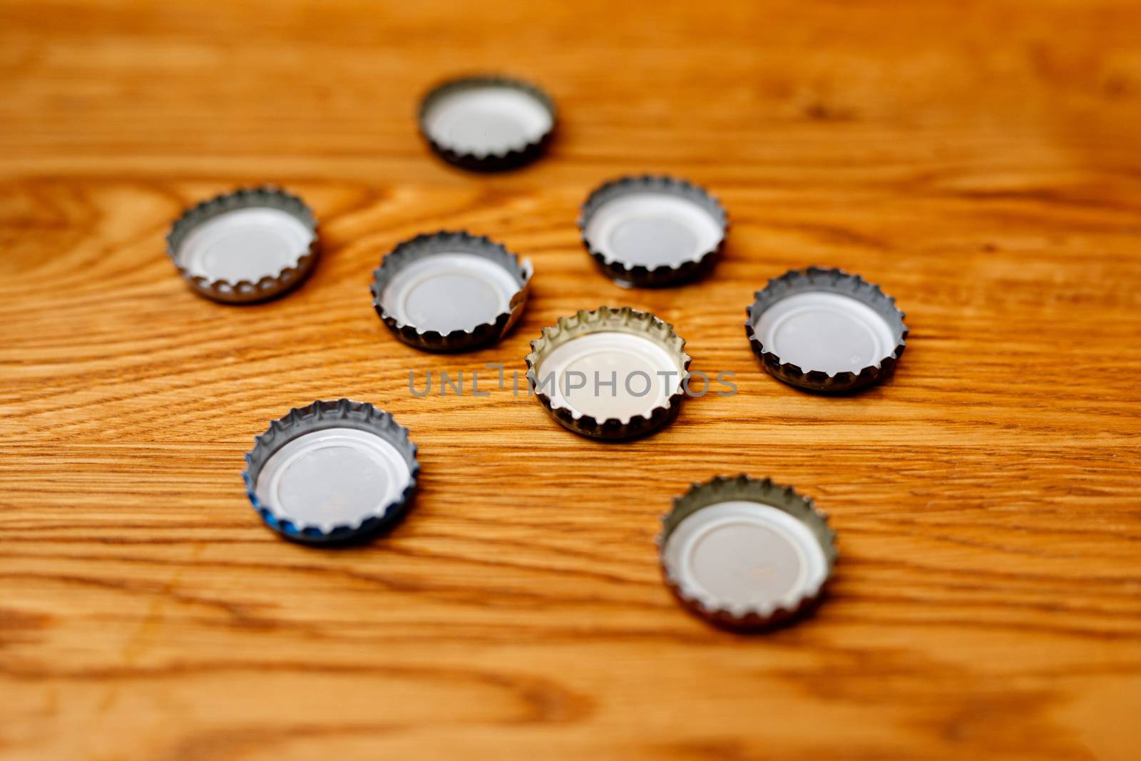 Beer bottle caps on a wooden table. by 9parusnikov