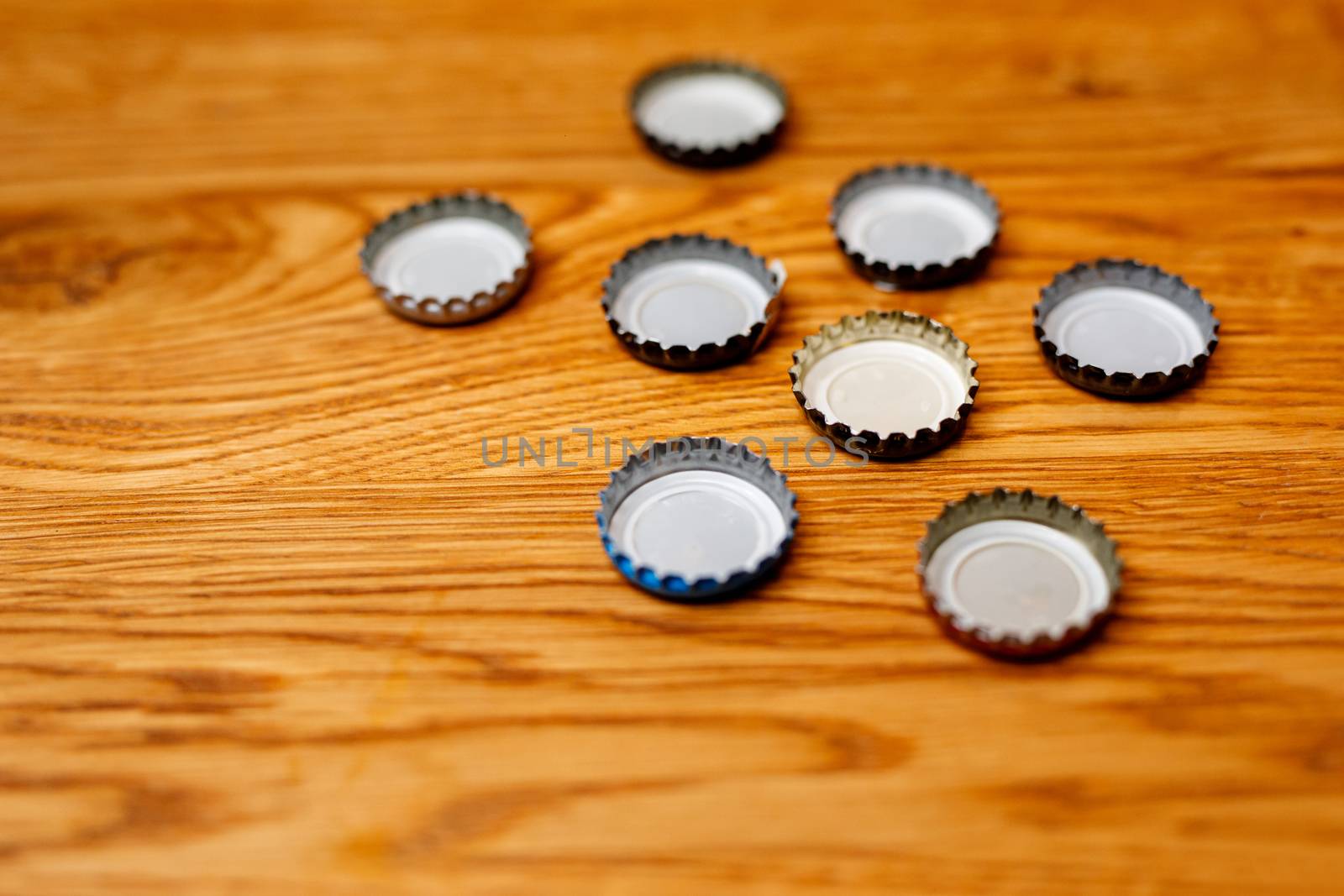 Beer bottle caps on a wooden table. by 9parusnikov