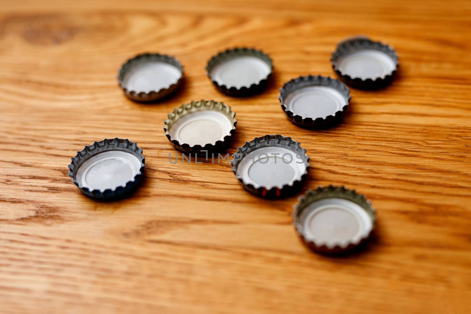 Beer bottle caps on a wooden table. by 9parusnikov