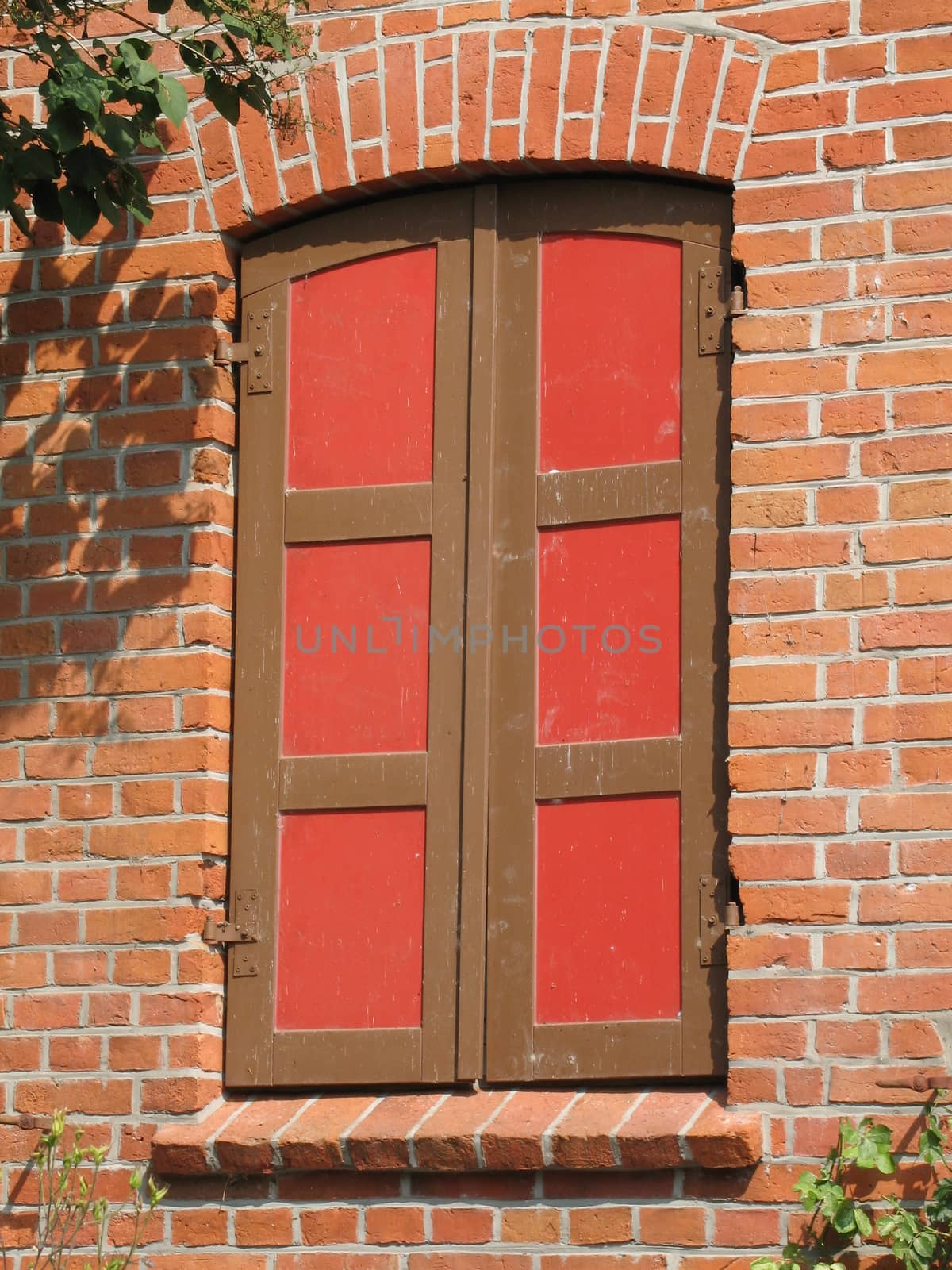 Shutters made of wood painted in the colors colours red and brown.