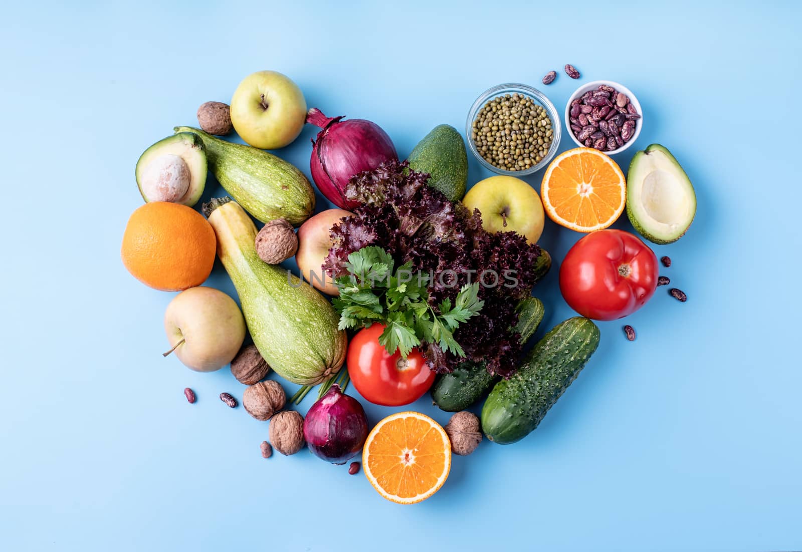 Healthy diet. Fresh fruit and vegetables in heart shape top view flat lay on blue background