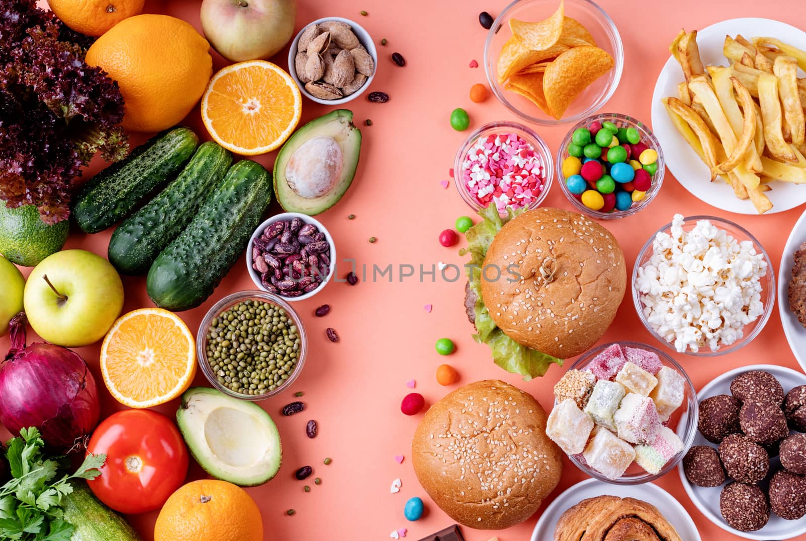 Fruit and vegetables vs sweets and fast food top view flat lay on orange background by Desperada