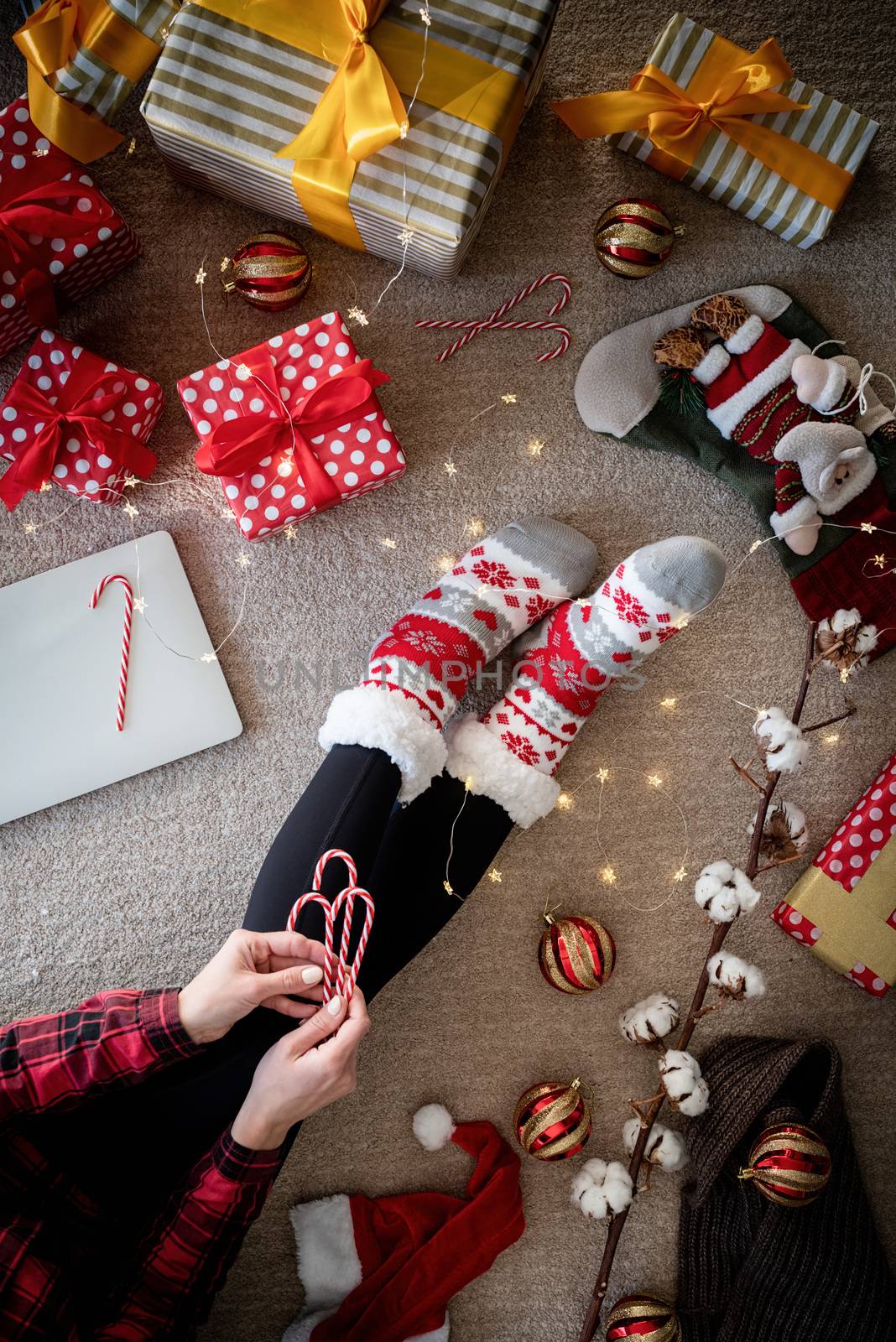 Top view of woman in funny socks celebrating Christmas at home by Desperada