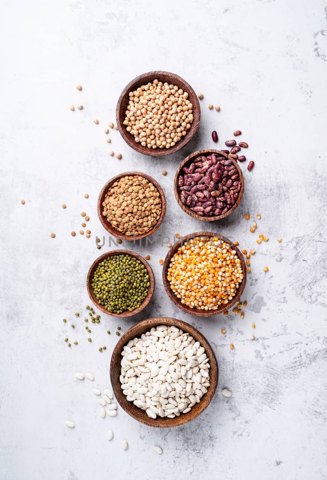 Various dried legumes in wooden bowls top view flat lay by Desperada