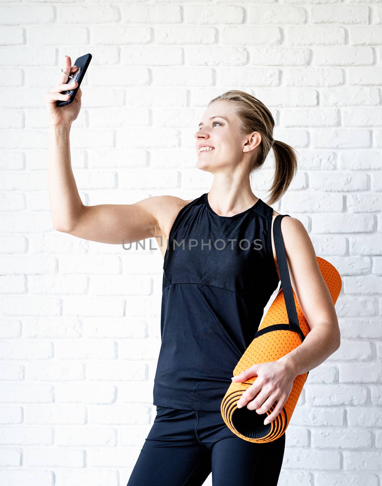 Healthy lifestyle. Sport and fitness. Young smiling fitness woman doing selfie after workout