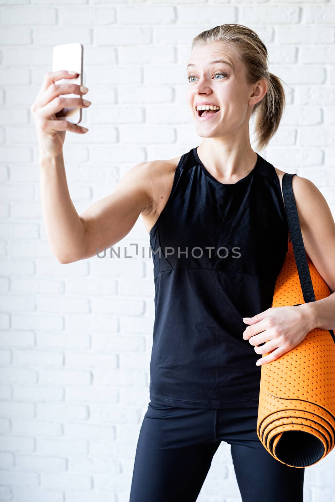 Young smiling fitness woman doing selfie after workout by Desperada