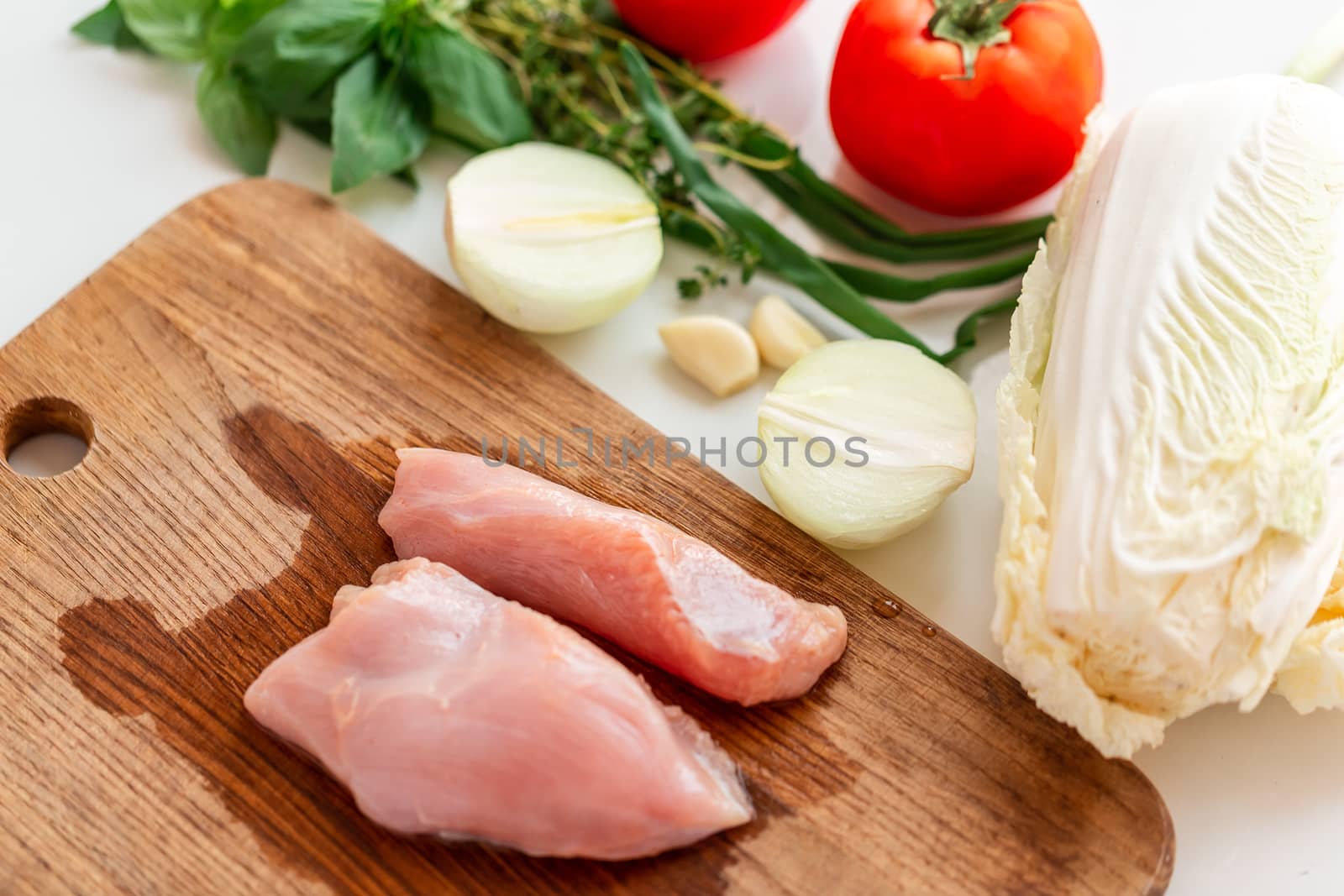 Cooking chicken tenders at home. Chicken fillet on the wooden board prepared to be cut