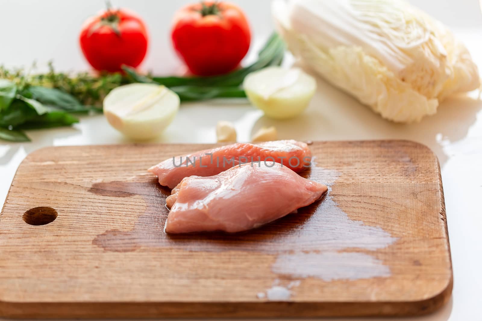 Cooking chicken tenders at home. Chicken fillet on the wooden board prepared to be cut