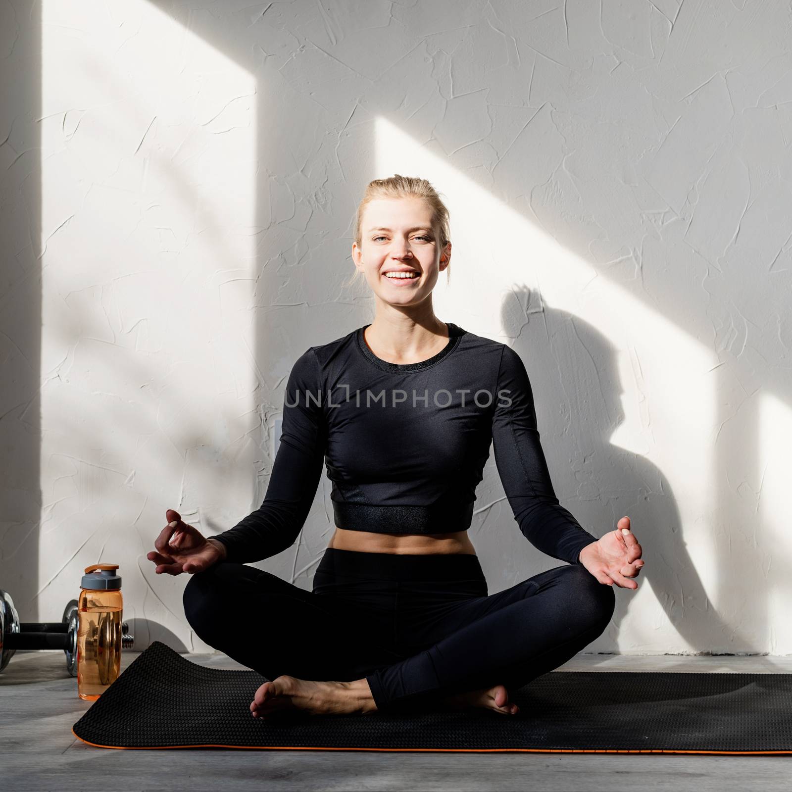 young blond woman doing yoga or meditating at home by Desperada