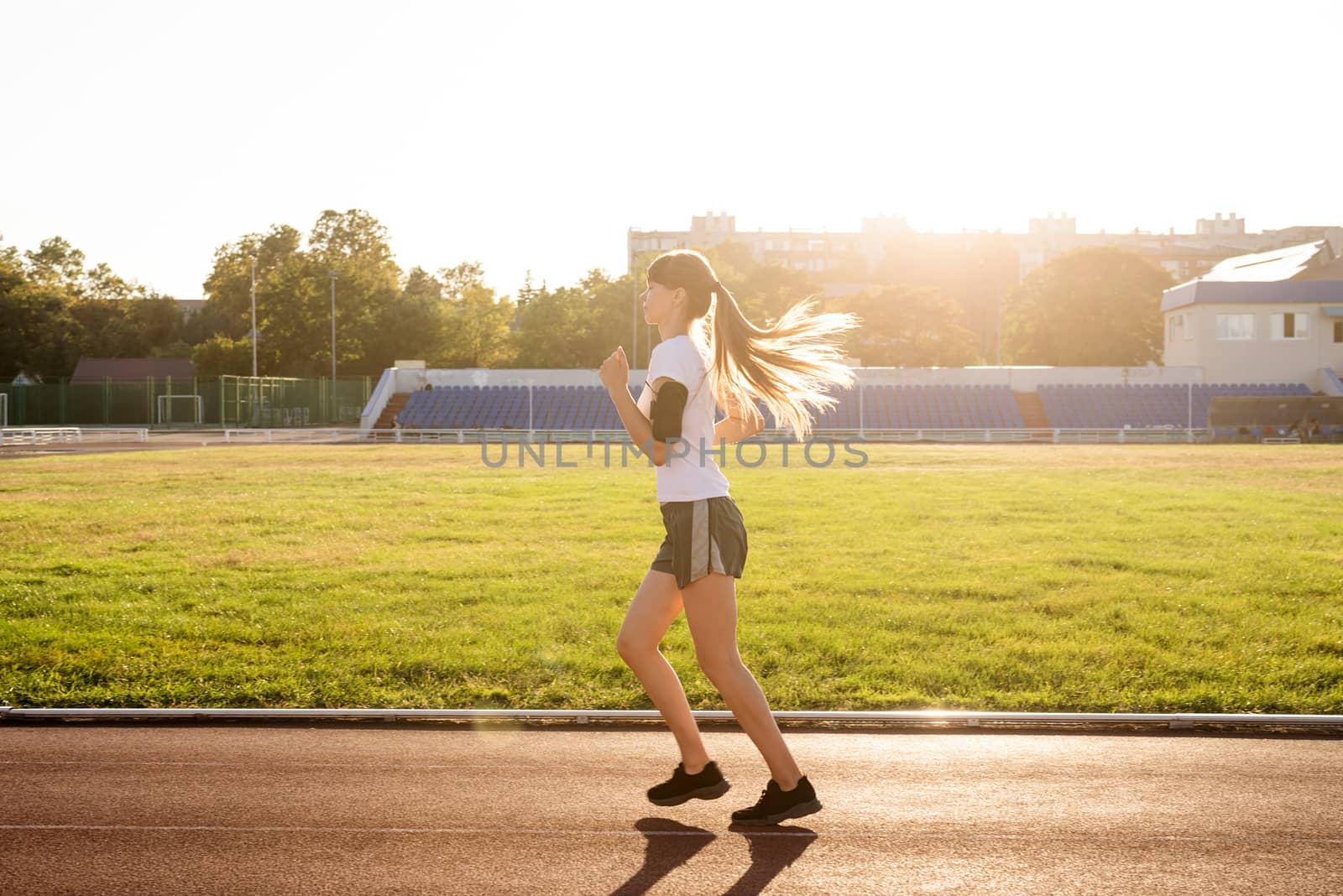 Healthy lifestyle concept. Active young woman jogging at the stadium