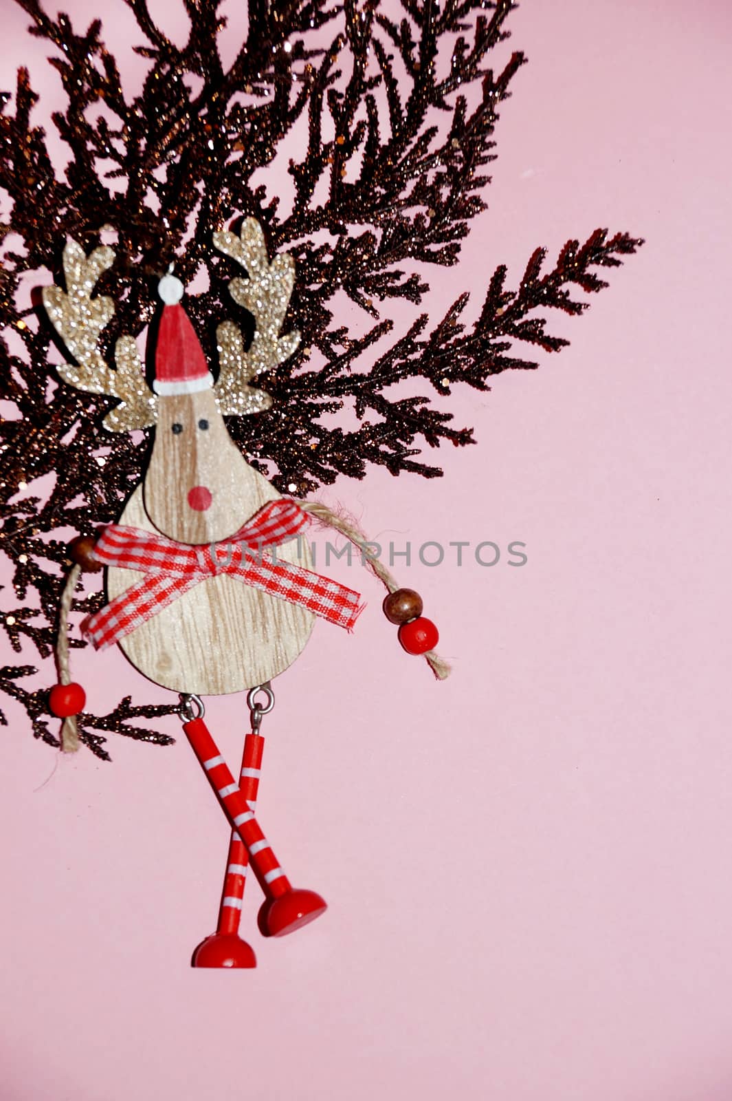 brown gilded branch and deer in santa hat on a pink background for Christmas blank, copy space