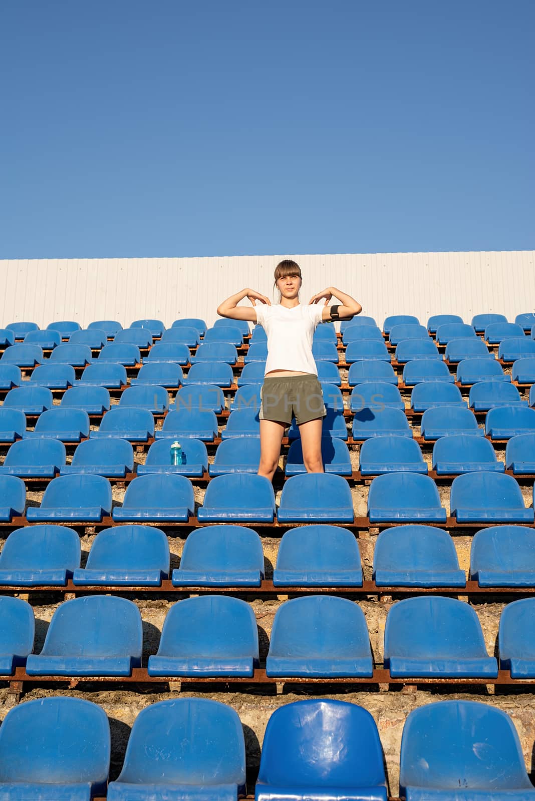 Teenage doing sports alone at the empty stadium by Desperada