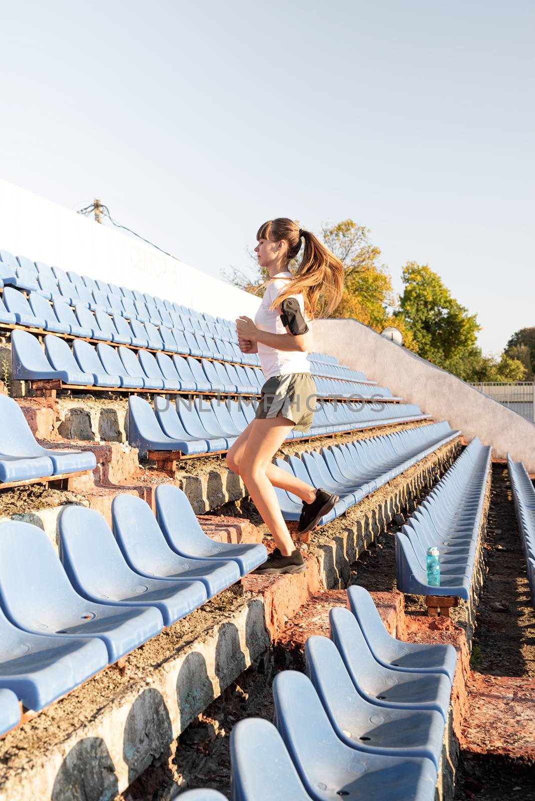 Active lifestyle. Teenager girl working out at the staduim running up the stairs