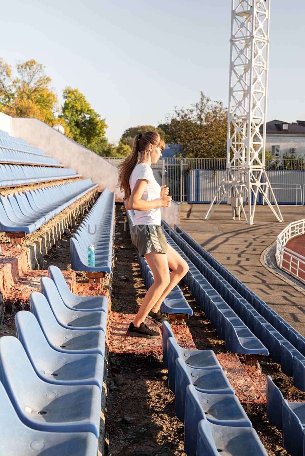 Active lifestyle. Teenager girl working out at the staduim running down the stairs