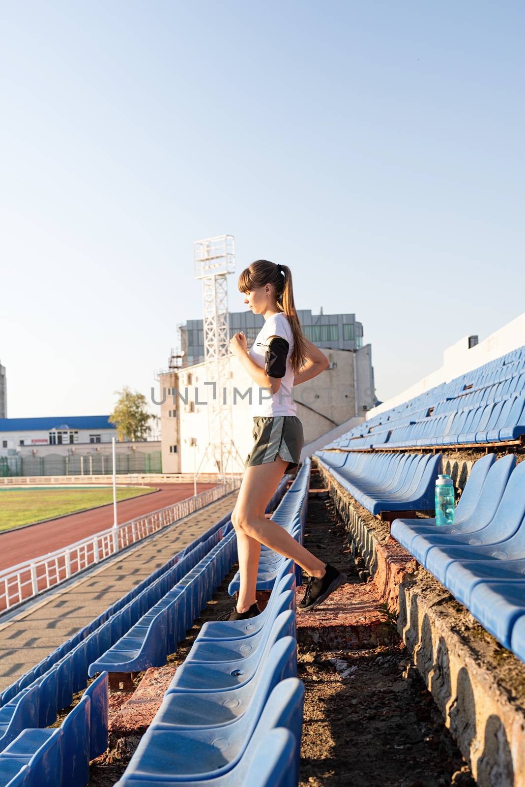 Active lifestyle. Teenager girl working out at the staduim running down the stairs