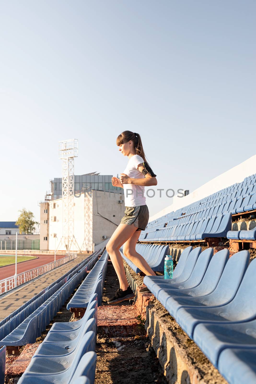 Active lifestyle. Teenager girl working out at the staduim running down the stairs