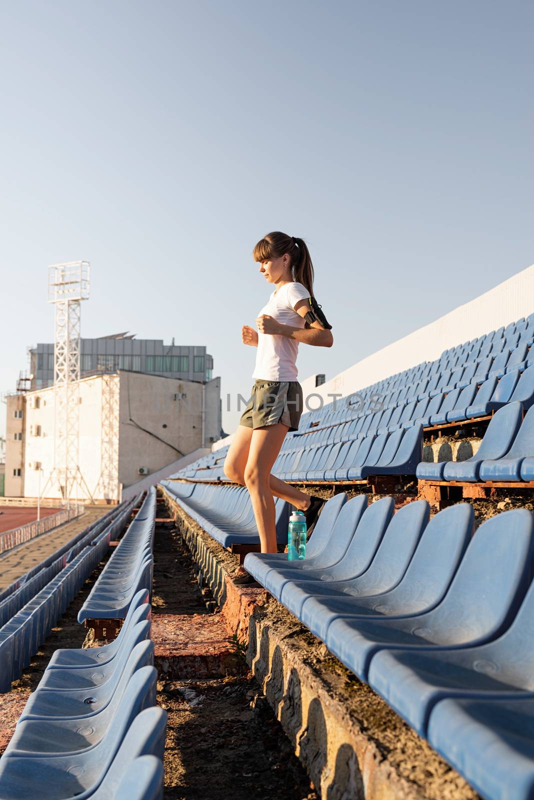 Active lifestyle. Teenager girl working out at the staduim running down the stairs