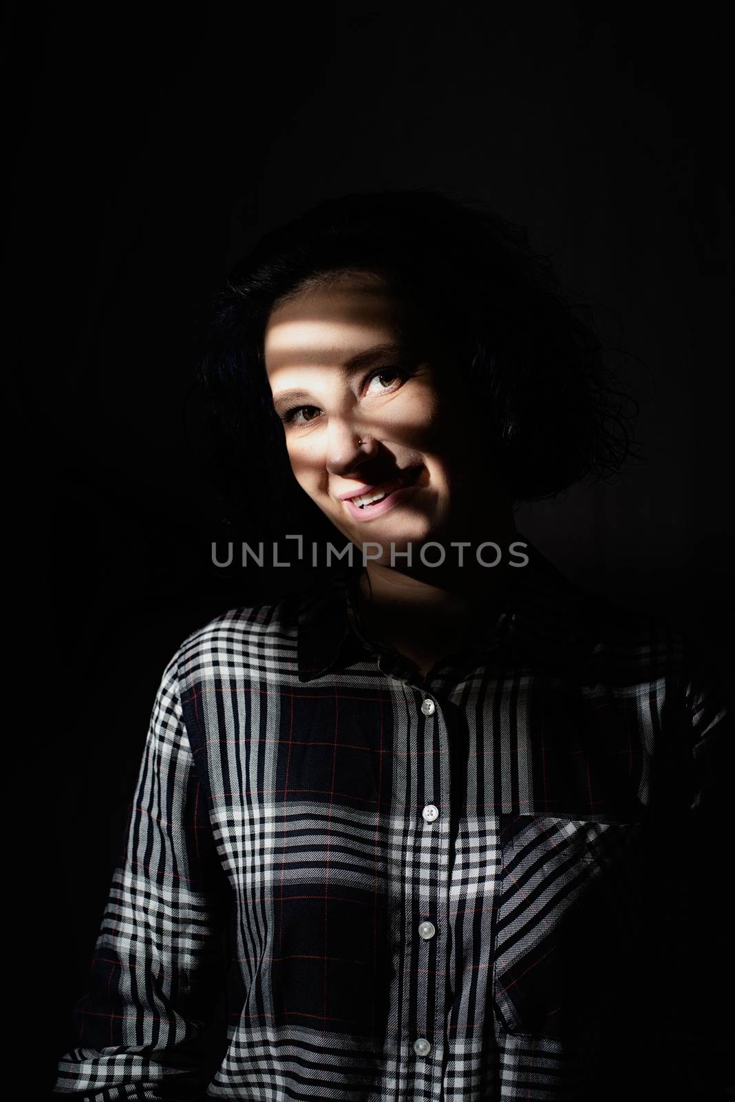 Light and shadow portrait. Beautiful young woman with a shadow pattern on the face in the form of stripes
