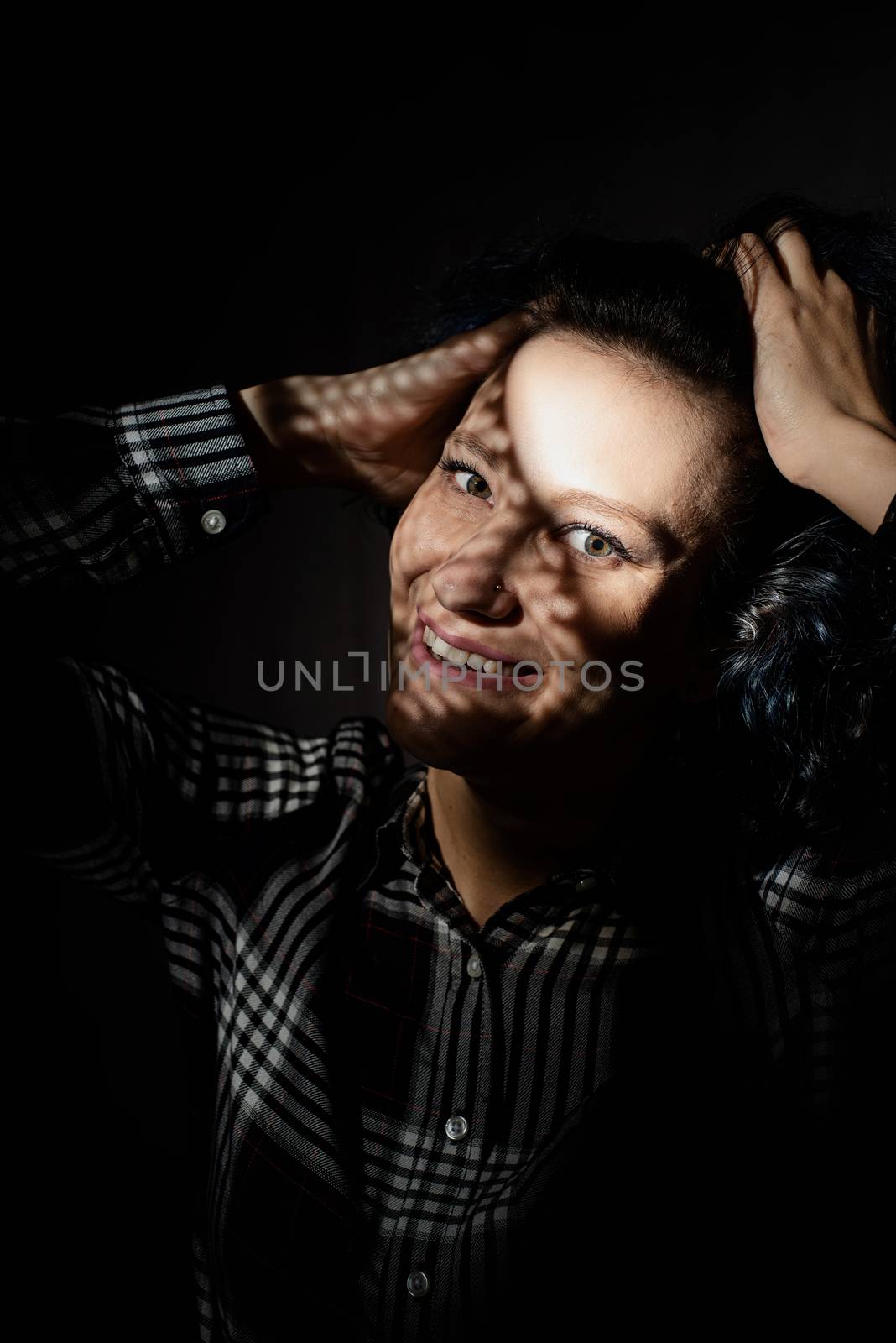 Portrait of a beautiful young woman with a creative shadow pattern on the face and body by Desperada