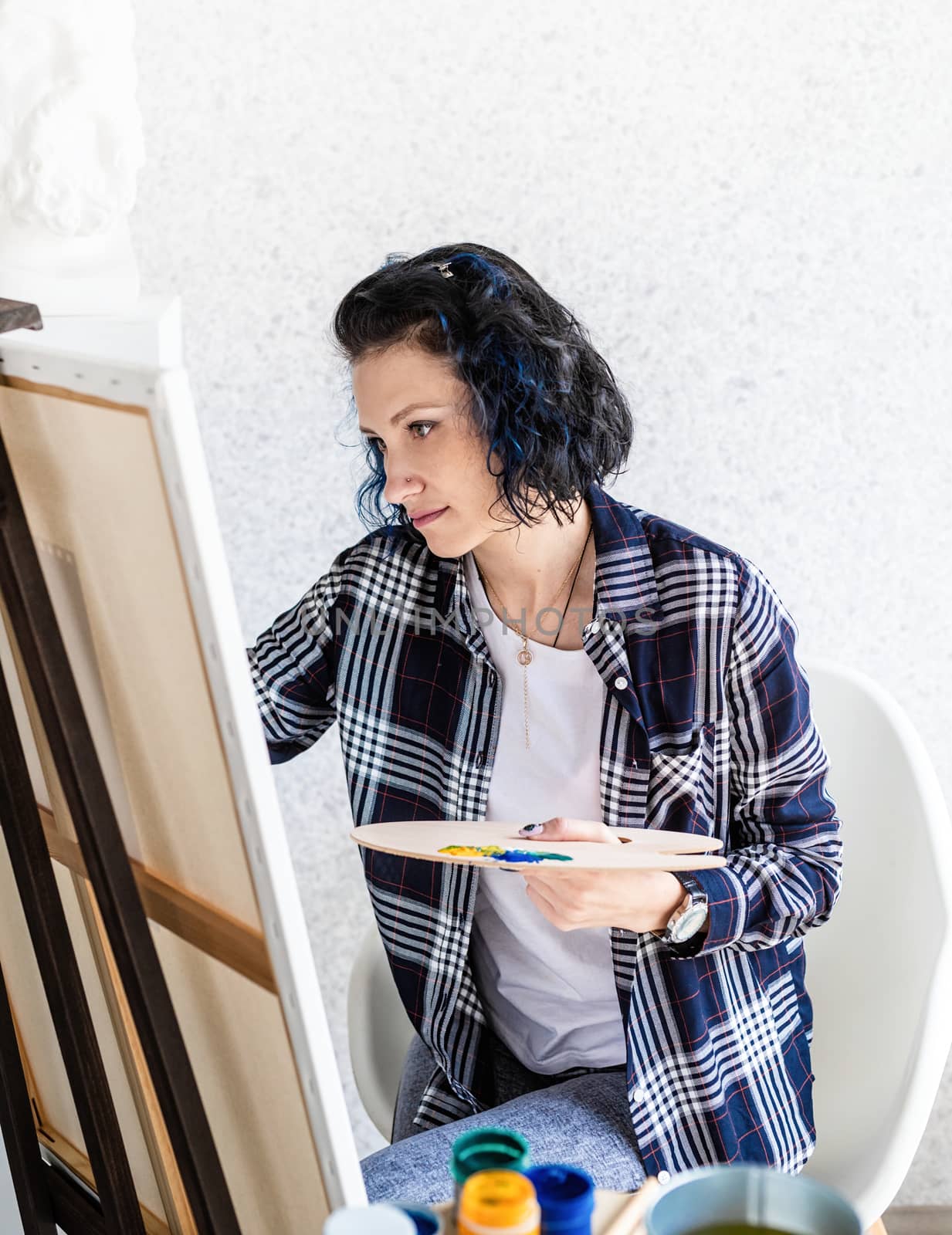 Creative woman artist painting a picture working in her studio