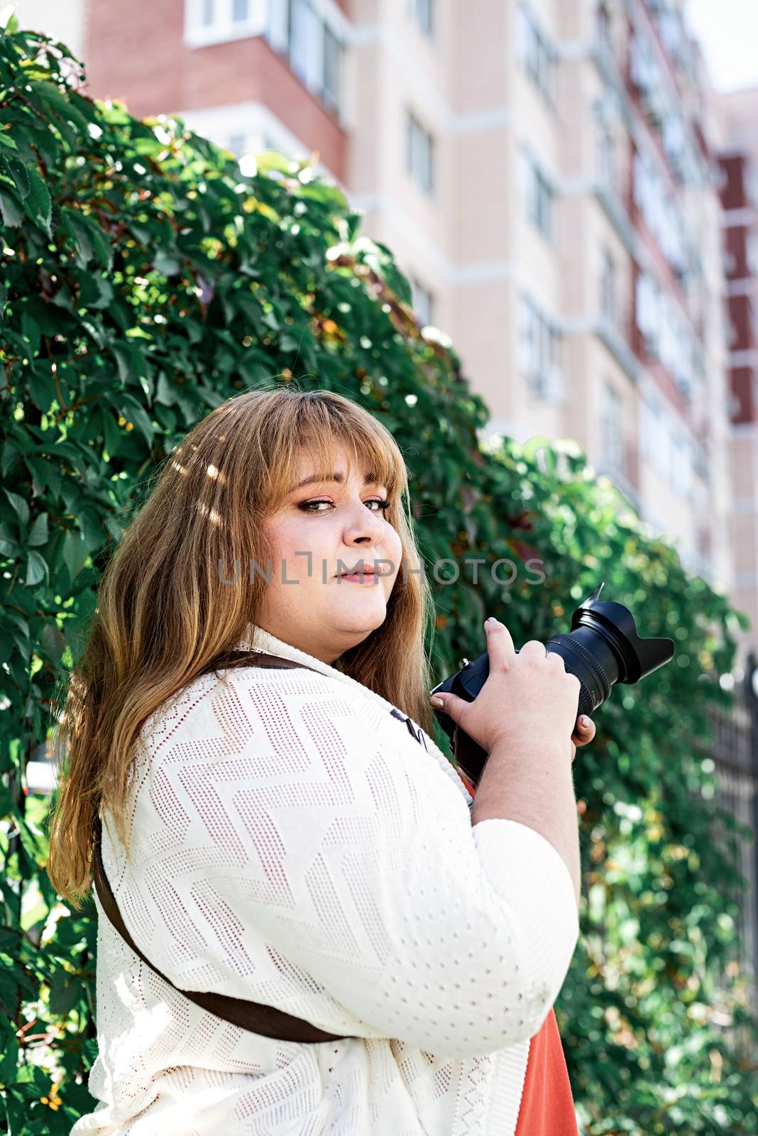 Travel, tourism and entertainment. Plus size woman photographer working at the street