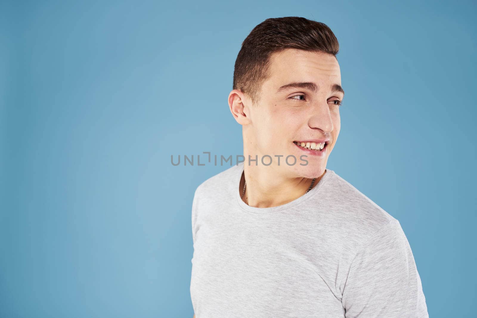 Emotional man in white t-shirt cropped view on blue background lifestyle. High quality photo