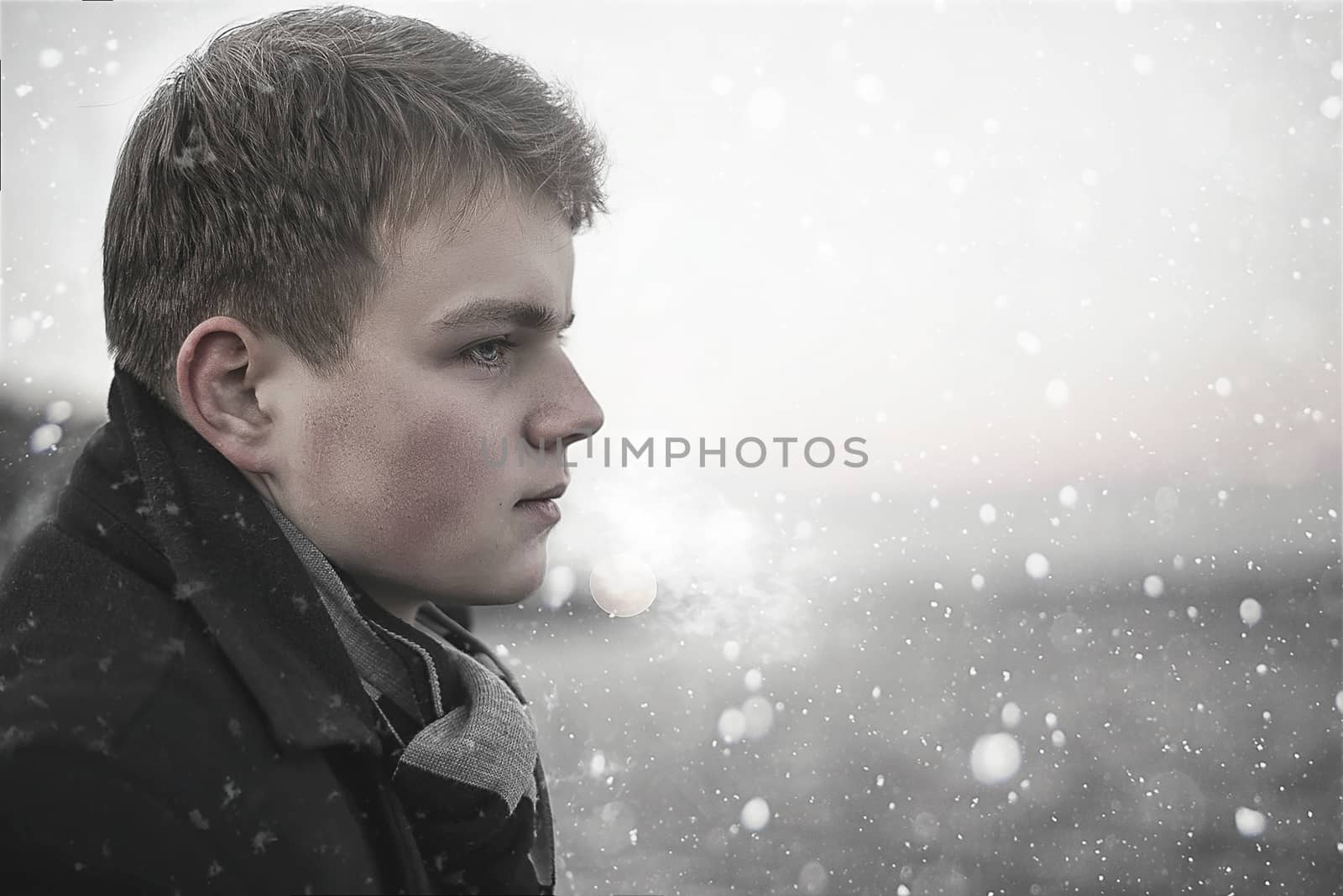 Portrait of handsome young Caucasian man looking away in a winter background. Concept about lifestyle, people, nature and travel.