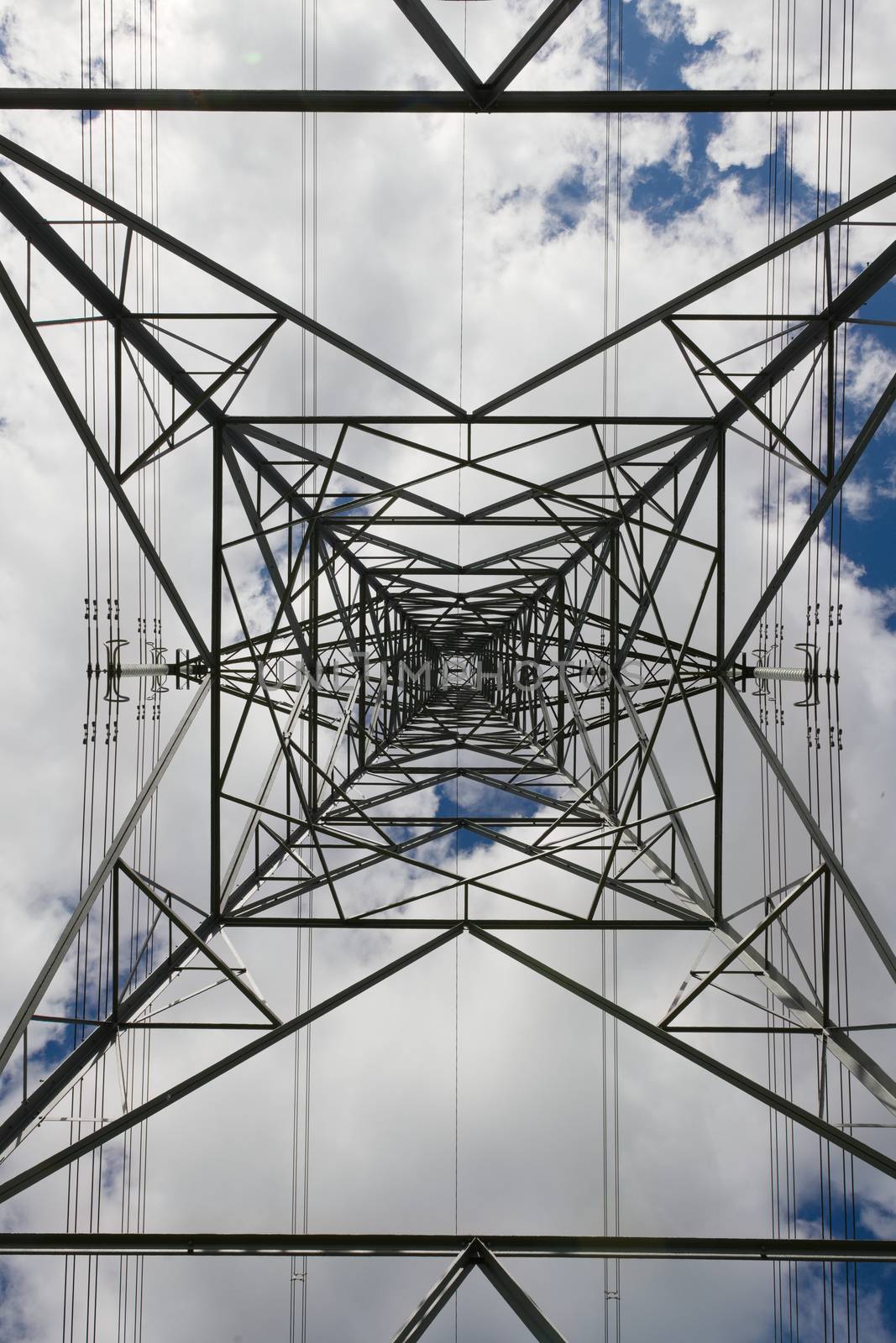 Abstract background texture image of power transmission lines running behind the metal lattice frame work of an electrical transmission tower.