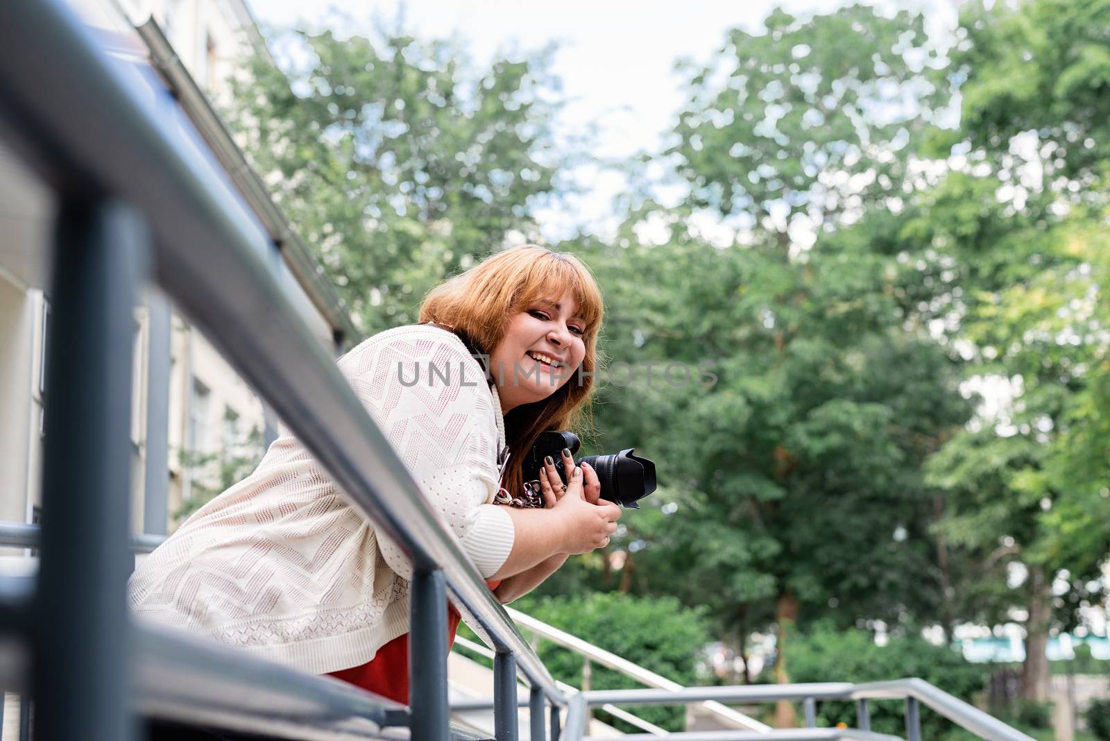 Travel, tourism and entertainment. Plus size woman photographer working at the street