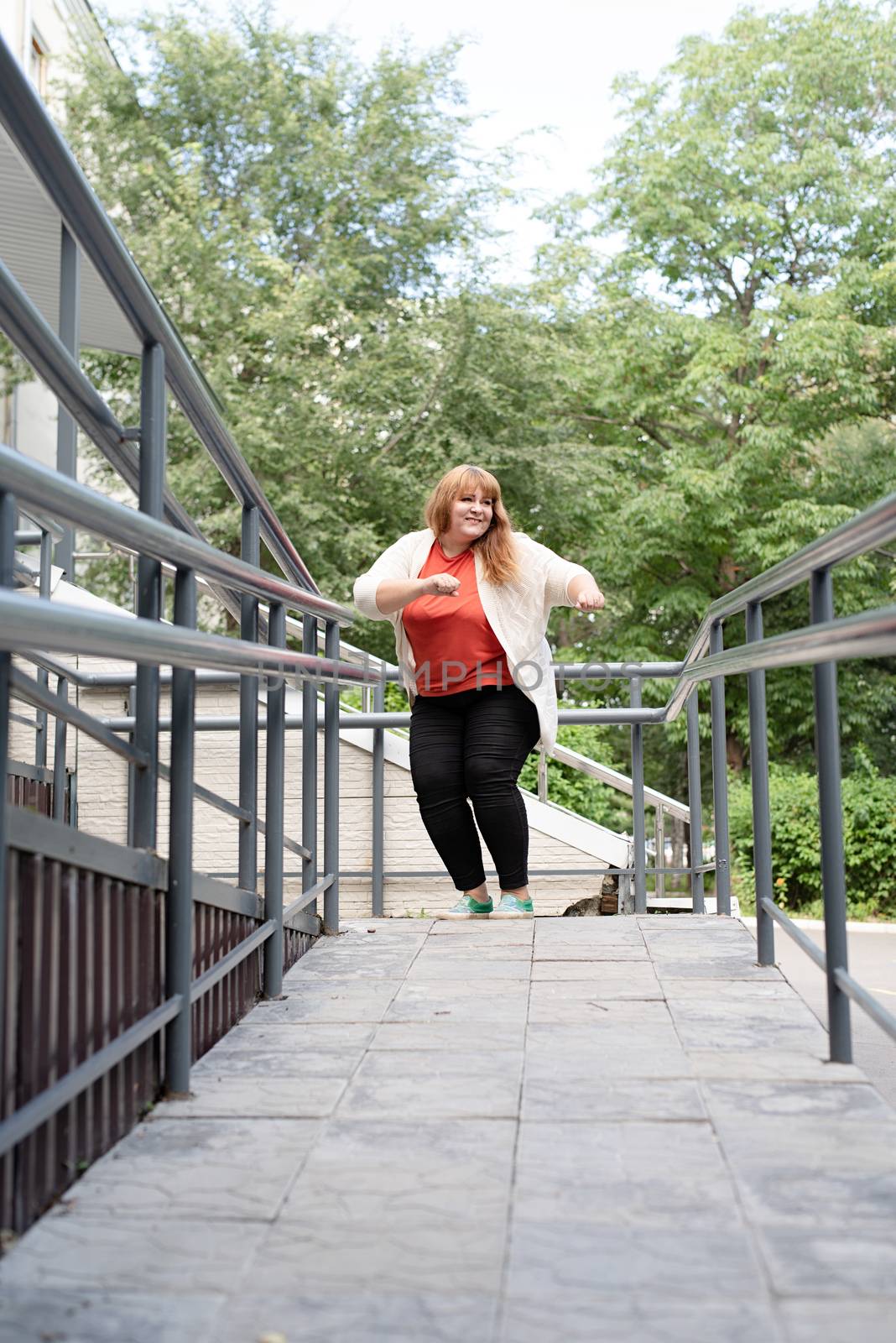 Portrait of a young beautiful caucasian woman dancing on the street having fun