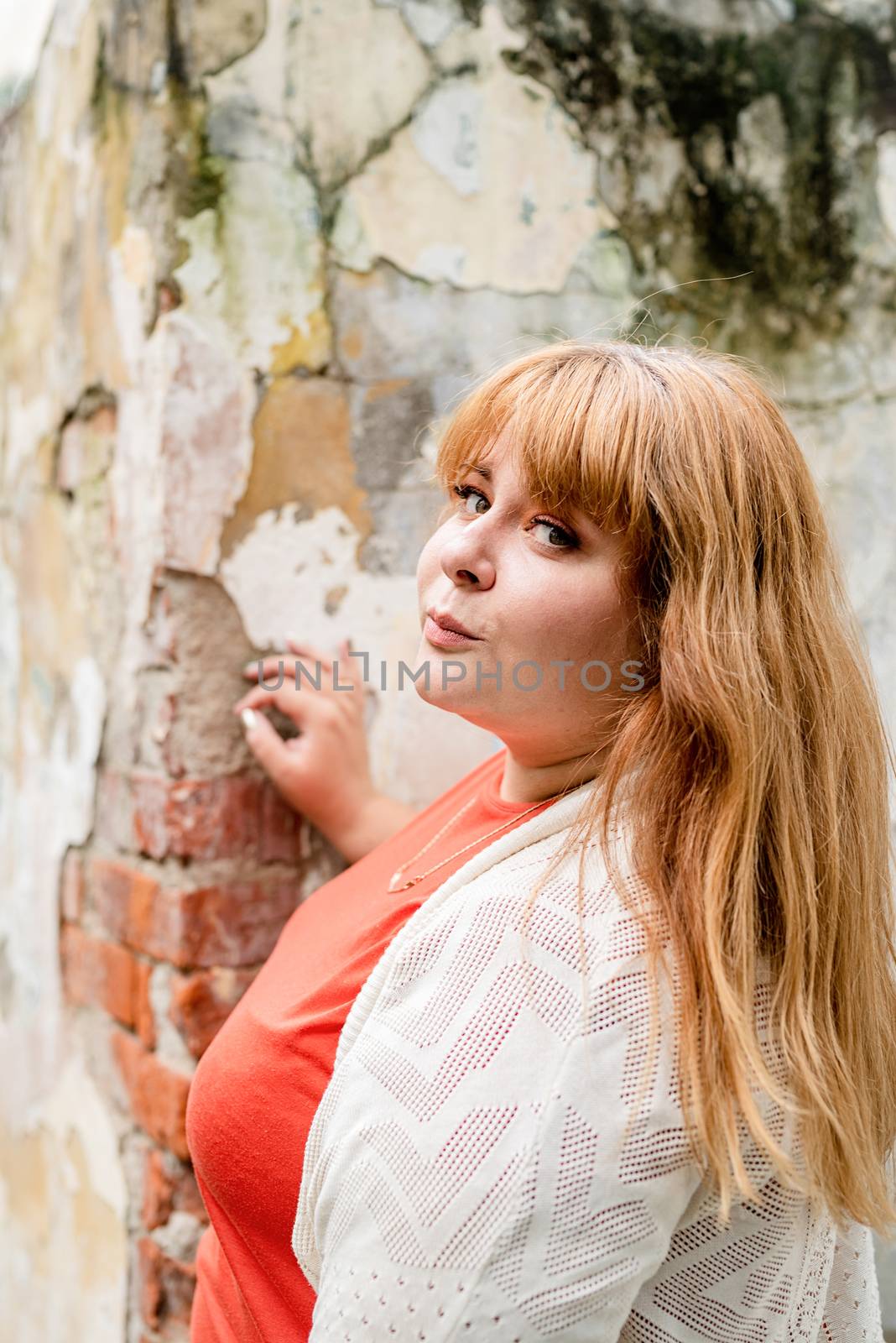 Portrait of a young beautiful caucasian plus size woman standing on the street smiling by Desperada