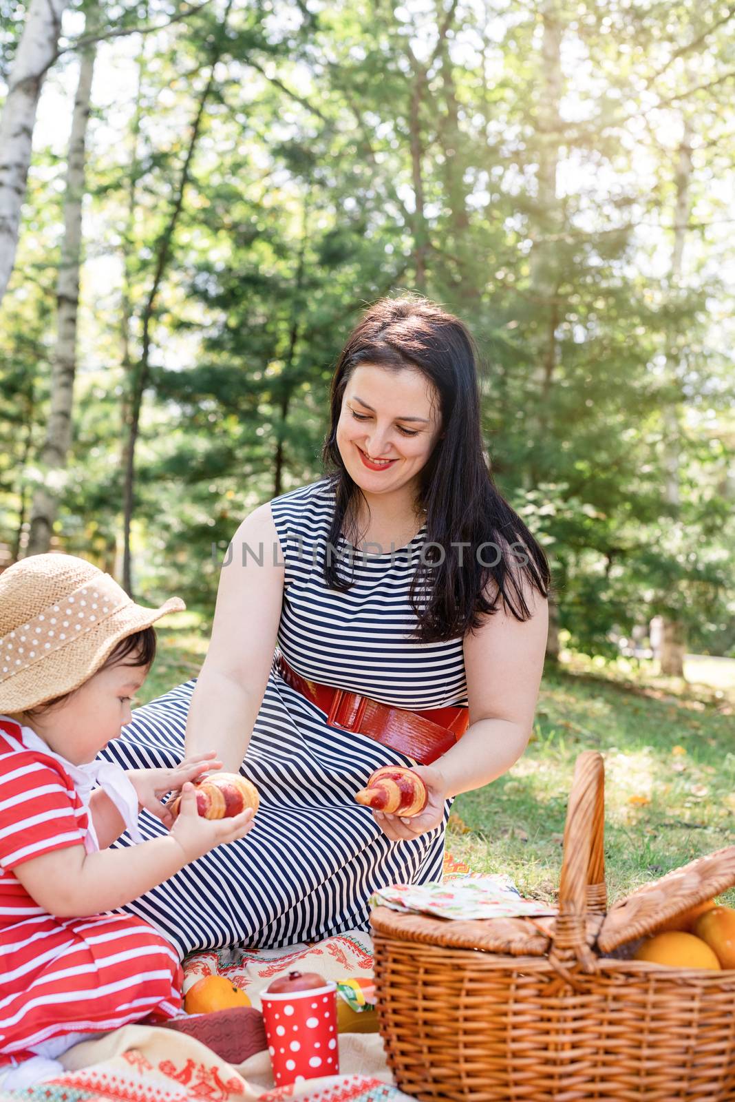 Parks and recreation. Interracial family. Interracial family of mother and daughter in the park having a picnic. Selective focus