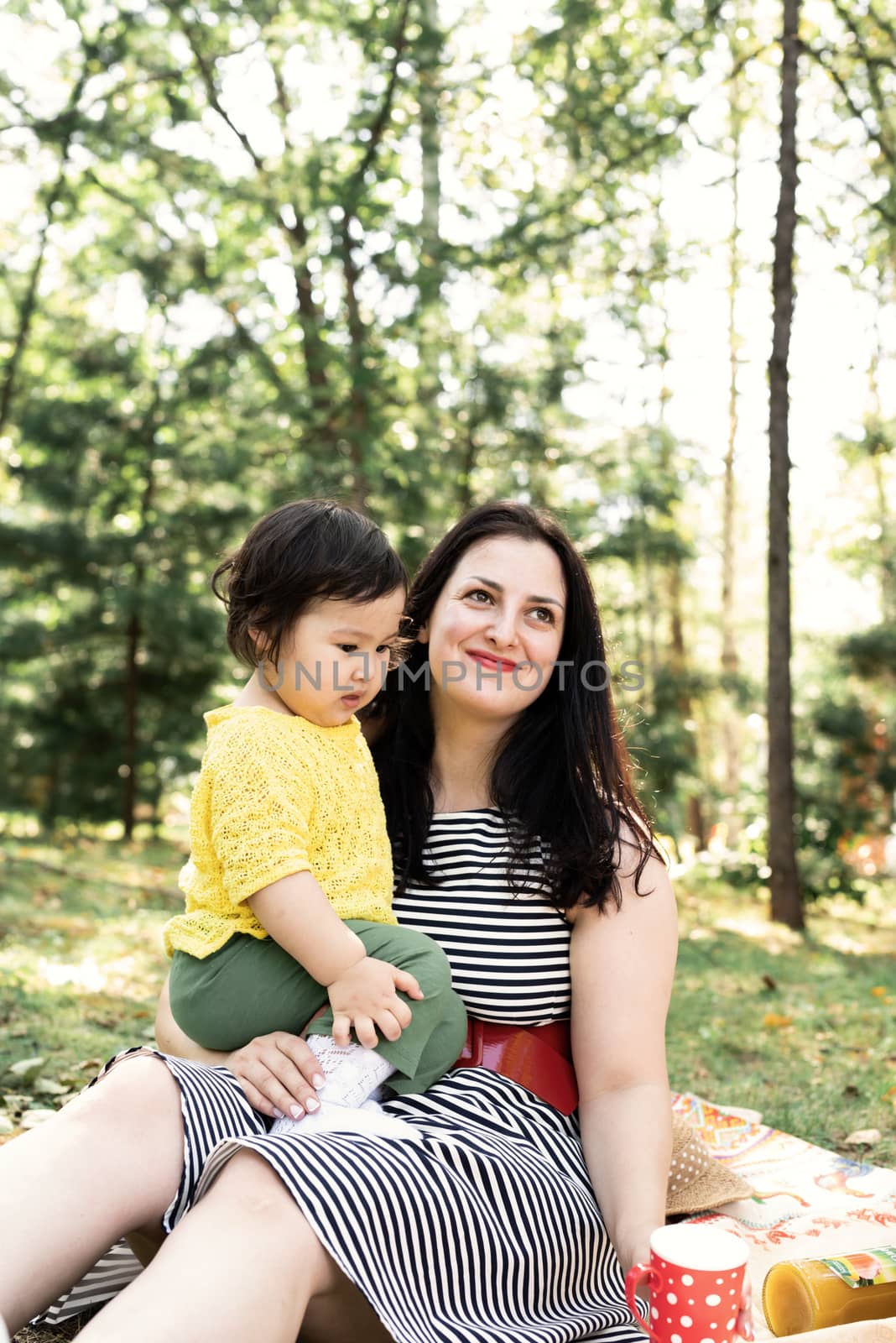 Multiethnic family. Happy multiracial family of mother and daughter in the park on a picnic