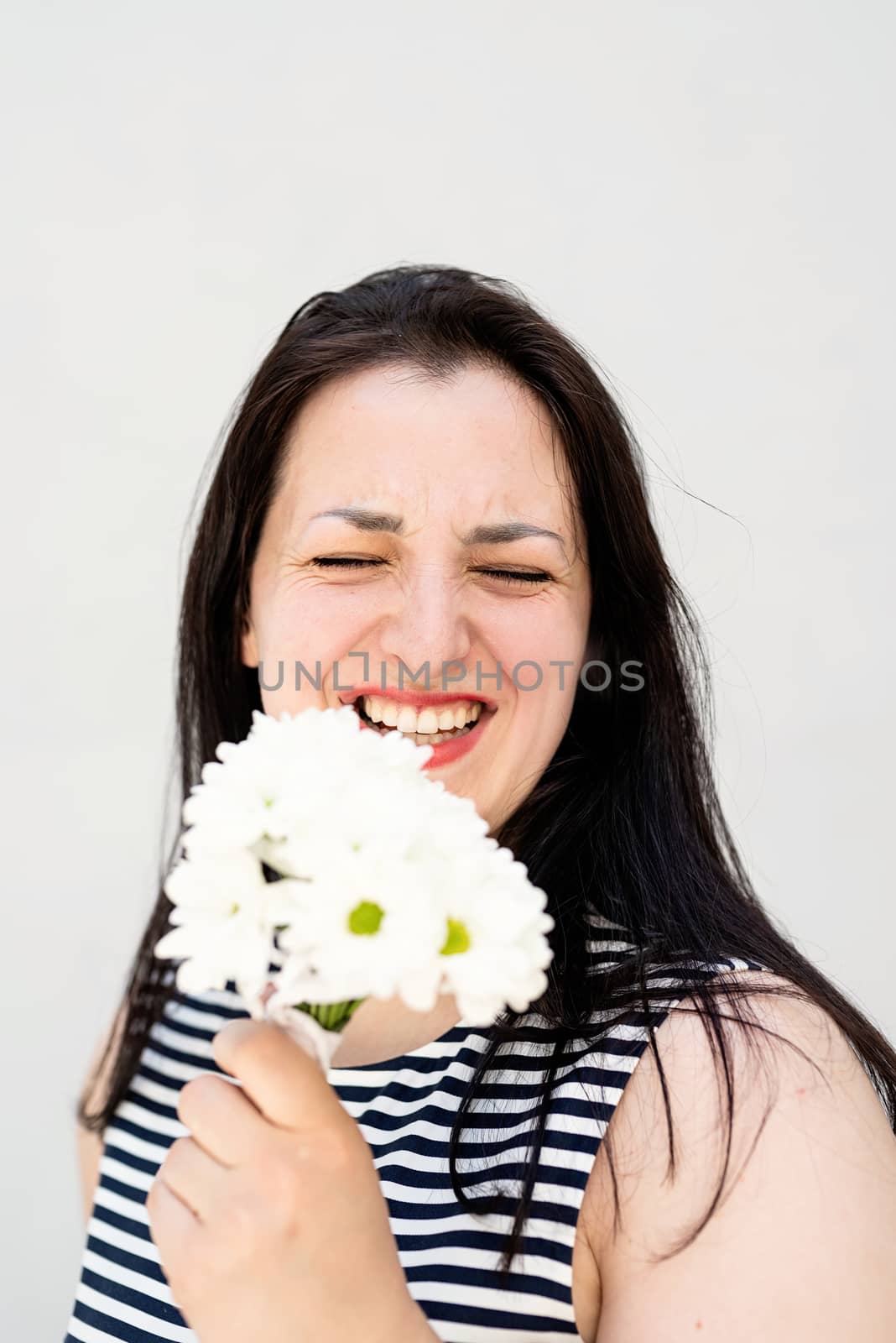 Portrait of laughing woman holding a bouquet of flowers by Desperada