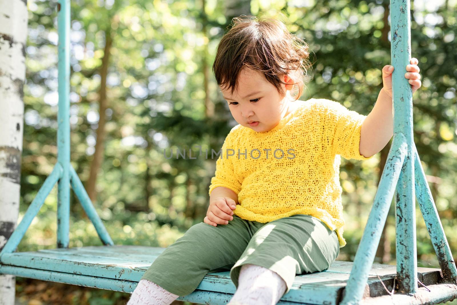 sad little infant girl sitting on the swing by Desperada