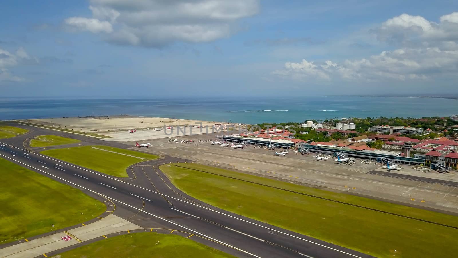 Airplane Parked on Ngurah Rai Airport Apron. Aerial view to international airport vith planes.